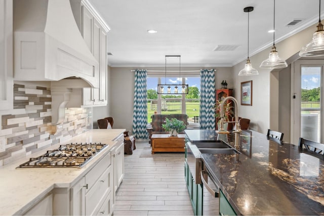 kitchen with visible vents, appliances with stainless steel finishes, tasteful backsplash, premium range hood, and white cabinetry