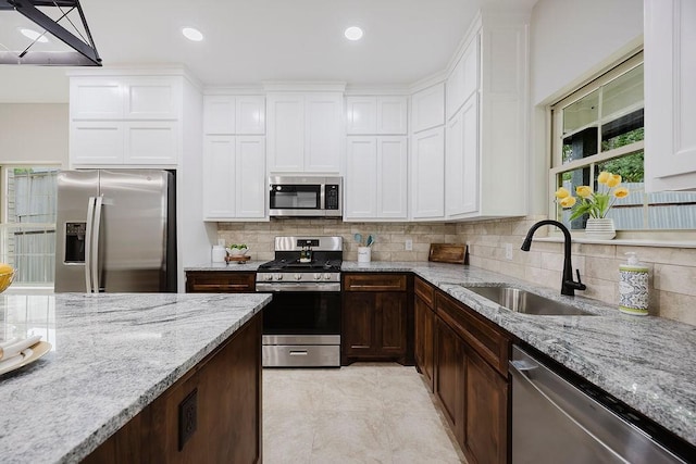 3600 Howard St, Fort Worth, TX 76119 - kitchen featuring stainless steel appliances, a sink, tasteful backsplash, light stone countertops, and recessed lighting