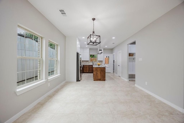 3600 Howard St, Fort Worth, TX 76119 - kitchen with freestanding refrigerator, a chandelier, plenty of natural light, backsplash, and recessed lighting
