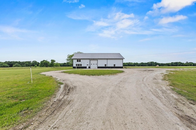 view of front of house featuring a detached garage, an outbuilding, an outdoor structure, and a front yard