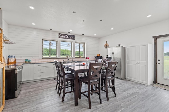 dining area featuring recessed lighting, light wood-style flooring, and a healthy amount of sunlight