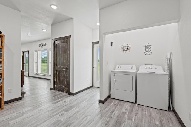 washroom with laundry area, baseboards, washing machine and dryer, and wood finished floors