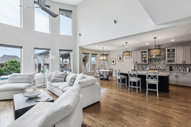 living room featuring recessed lighting, a high ceiling, and dark wood-type flooring