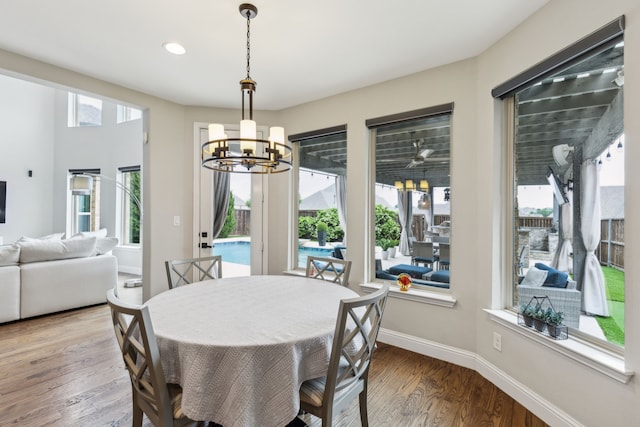 dining area with an inviting chandelier, baseboards, recessed lighting, and wood finished floors