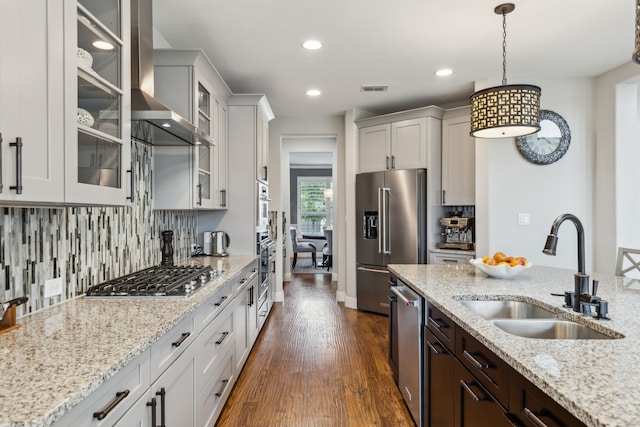 kitchen with visible vents, pendant lighting, a sink, backsplash, and stainless steel appliances