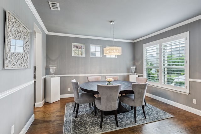 dining area with crown molding, a notable chandelier, wood finished floors, and visible vents