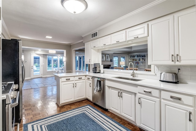 kitchen featuring crown molding, appliances with stainless steel finishes, a sink, white cabinetry, and visible vents