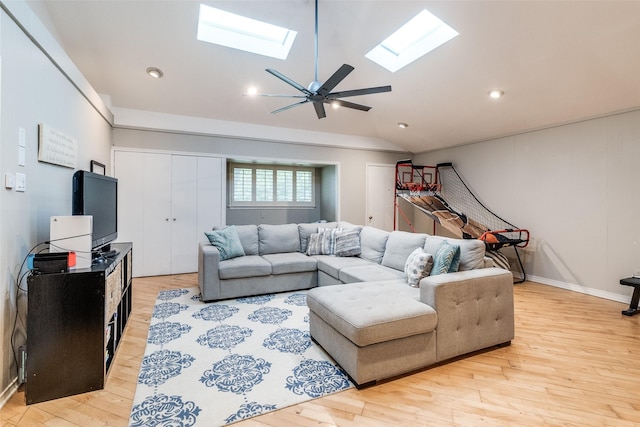 living room featuring recessed lighting, ceiling fan, light wood-style flooring, and lofted ceiling with skylight