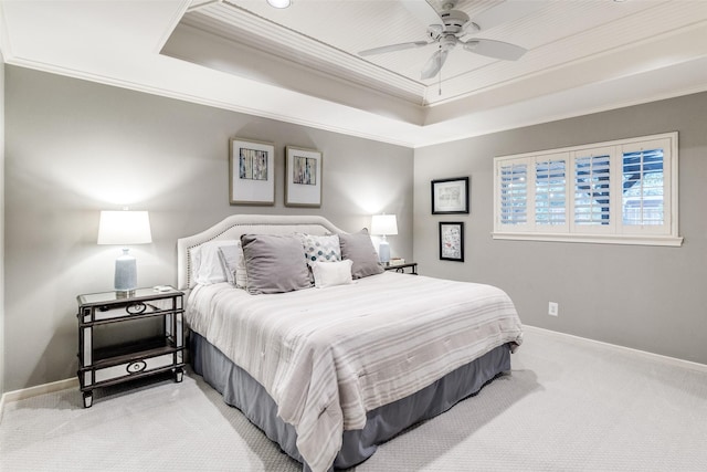 carpeted bedroom featuring a raised ceiling, ornamental molding, baseboards, and ceiling fan