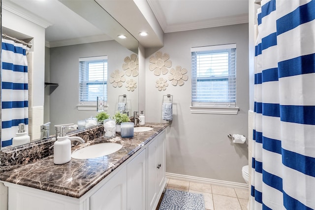 bathroom with crown molding, double vanity, baseboards, and a sink