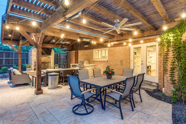 view of patio featuring ceiling fan, fence, an outdoor stone fireplace, outdoor dining area, and area for grilling