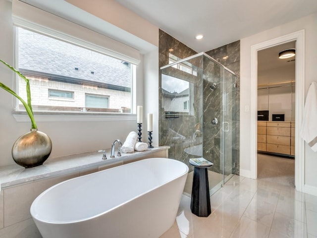 bathroom with a soaking tub, a stall shower, and marble finish floor