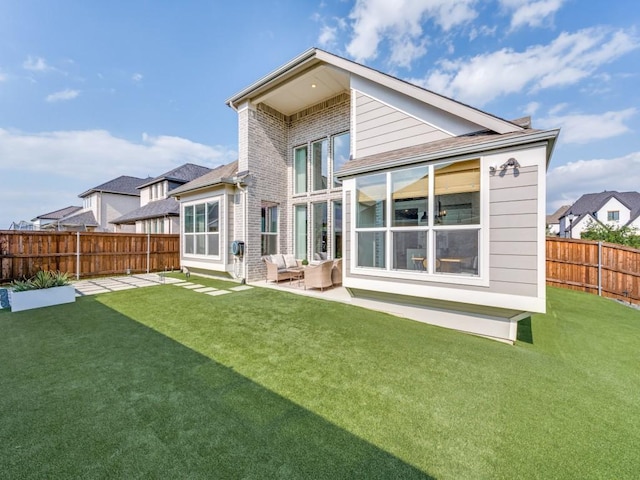 rear view of property featuring a lawn, a fenced backyard, outdoor lounge area, and a patio area