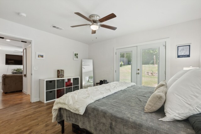 bedroom with multiple windows, french doors, visible vents, wood finished floors, and access to outside