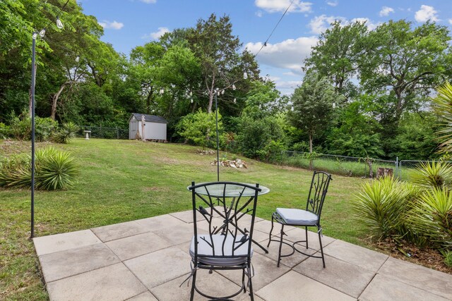 view of patio featuring an outbuilding, a fenced backyard, and a storage unit
