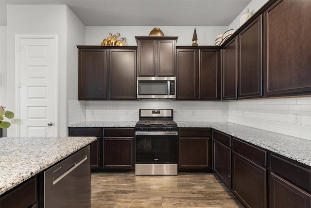kitchen with tasteful backsplash, stainless steel appliances, dark wood-style floors, and dark brown cabinets