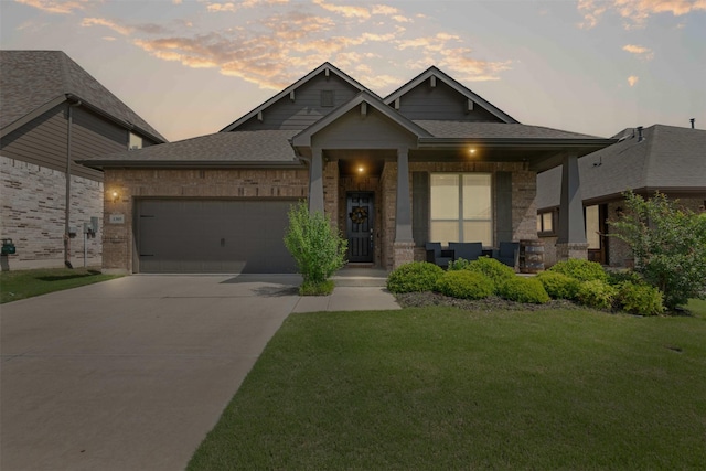 craftsman-style home with covered porch, a front yard, brick siding, concrete driveway, and an attached garage