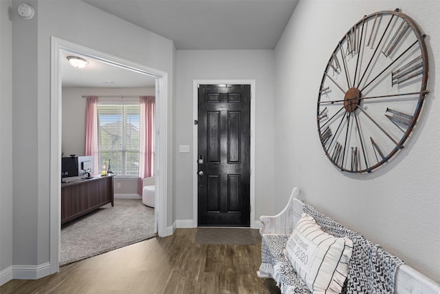 foyer featuring baseboards and wood finished floors