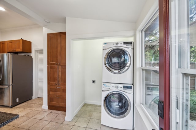 906 N Clinton Ave, Dallas, TX 75208 - washroom featuring baseboards, light tile patterned floors, laundry area, and stacked washer / dryer