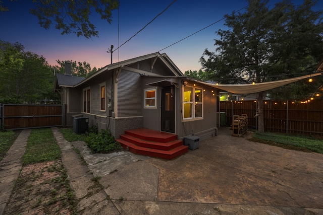 906 N Clinton Ave, Dallas, TX 75208 - back of property at dusk with a fenced backyard, a patio area, a chimney, and central AC unit