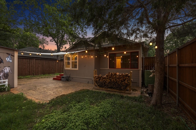 906 N Clinton Ave, Dallas, TX 75208 - back of house at dusk with a yard, an outbuilding, a fenced backyard, and a patio area
