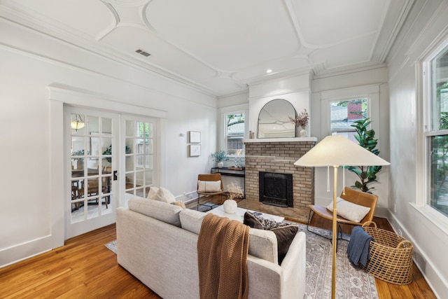 906 N Clinton Ave, Dallas, TX 75208 - living room with ornamental molding, a brick fireplace, wood finished floors, and visible vents