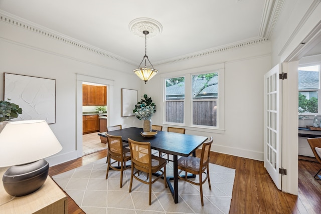 906 N Clinton Ave, Dallas, TX 75208 - dining space with crown molding, baseboards, and light wood finished floors
