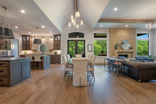 dining space with a healthy amount of sunlight, wood finished floors, and a chandelier