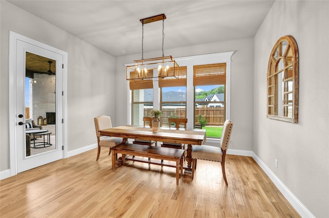 dining area featuring baseboards, light wood-style flooring, and a chandelier