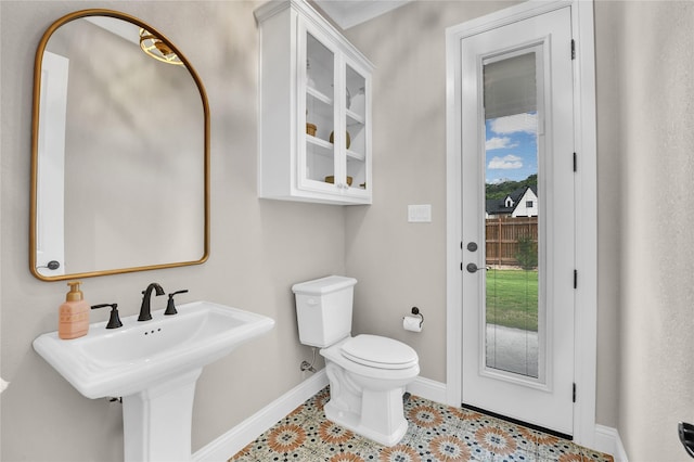 half bathroom featuring baseboards and toilet