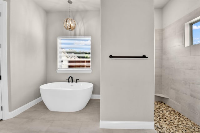 full bathroom with a walk in shower, baseboards, tile patterned floors, a notable chandelier, and a soaking tub