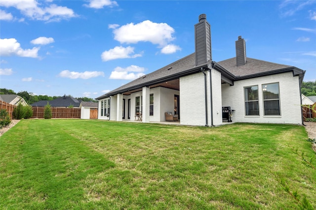 back of property featuring a storage shed, fence, a chimney, and an outbuilding
