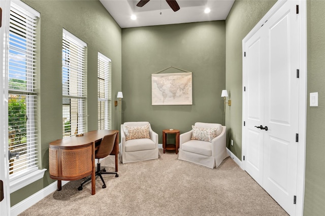 living area with carpet flooring, a ceiling fan, and a textured wall