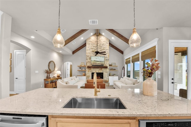 kitchen with visible vents, a ceiling fan, open floor plan, arched walkways, and a sink