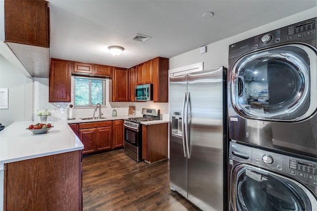 3158 Newcastle Dr, Dallas, TX 75220 - kitchen with appliances with stainless steel finishes, a sink, light countertops, dark wood-type flooring, and stacked washer and clothes dryer