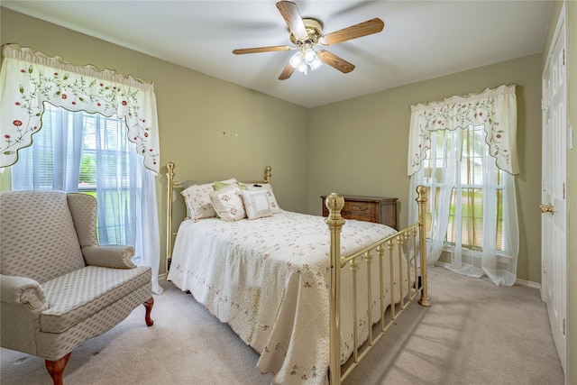 bedroom with baseboards, ceiling fan, and light colored carpet