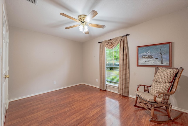 sitting room with baseboards, a ceiling fan, wood finished floors, and visible vents
