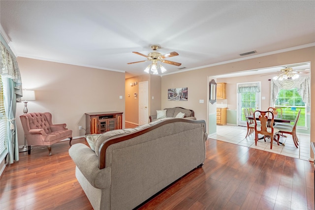 living room featuring visible vents, ornamental molding, ceiling fan, and hardwood / wood-style floors