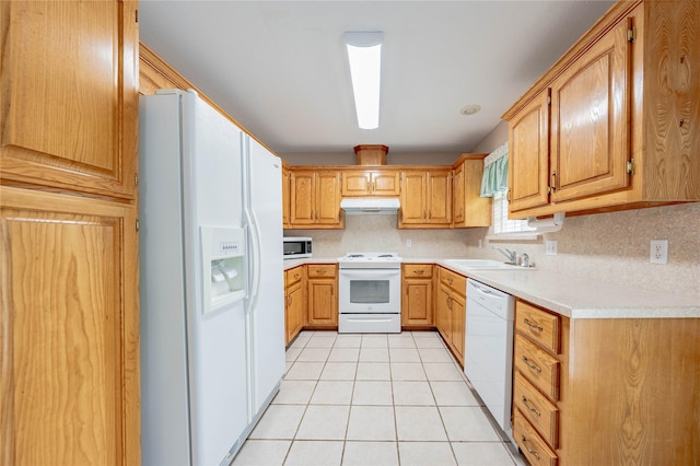 kitchen featuring a sink, light countertops, under cabinet range hood, and white appliances