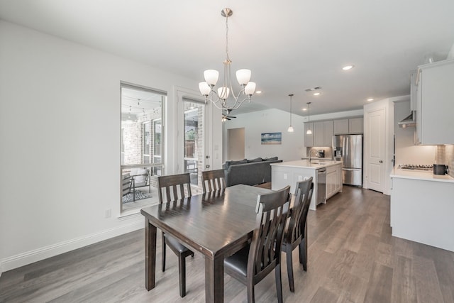 dining room with an inviting chandelier, baseboards, recessed lighting, and wood finished floors