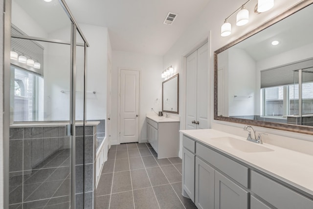 full bathroom featuring an enclosed shower, visible vents, two vanities, and a sink