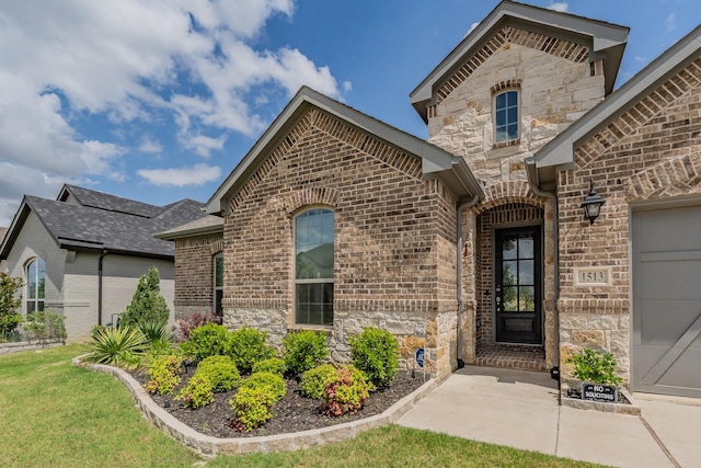 doorway to property with brick siding and stone siding