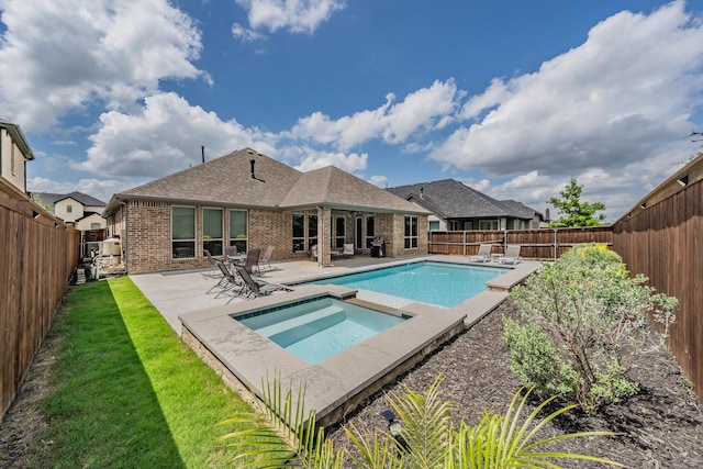 view of swimming pool featuring an in ground hot tub, a lawn, a patio area, a fenced in pool, and a fenced backyard