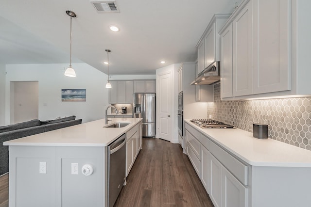 kitchen featuring backsplash, visible vents, a sink, under cabinet range hood, and stainless steel appliances