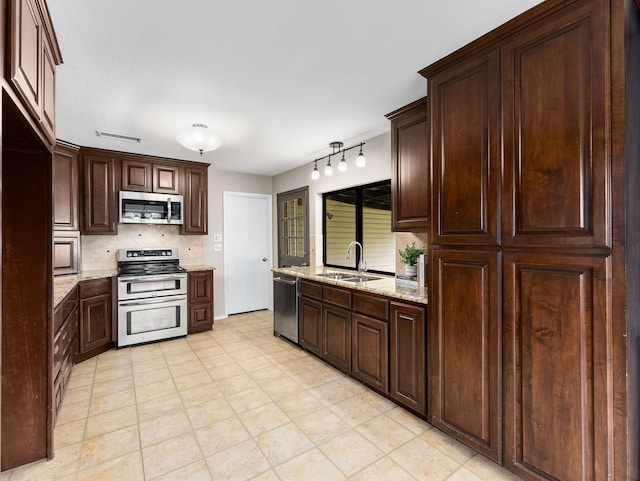 kitchen featuring visible vents, dark brown cabinets, tasteful backsplash, a sink, and stainless steel appliances