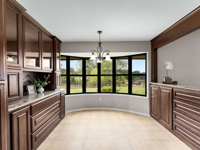 unfurnished dining area featuring baseboards and a chandelier