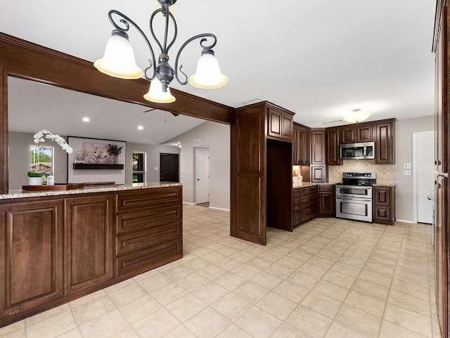 kitchen featuring dark brown cabinetry, hanging light fixtures, vaulted ceiling, light stone counters, and stainless steel appliances