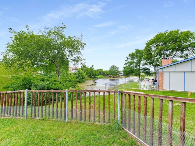 view of yard featuring a water view and fence