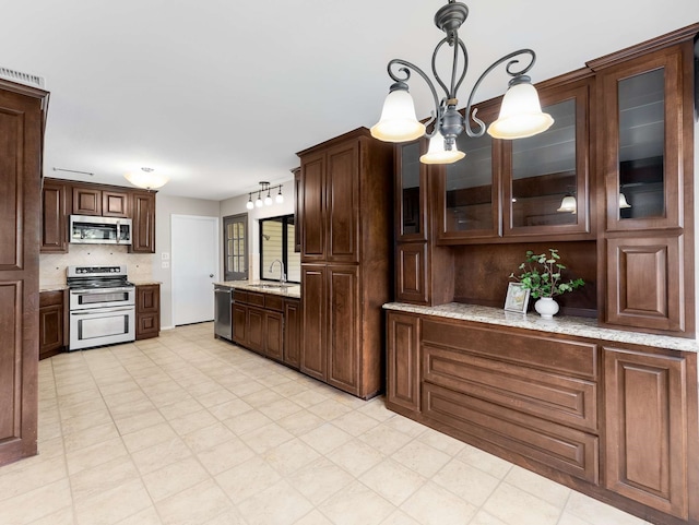 kitchen featuring a sink, appliances with stainless steel finishes, and dark brown cabinetry