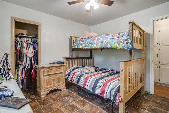 bedroom with a closet, a ceiling fan, and stone finish floor